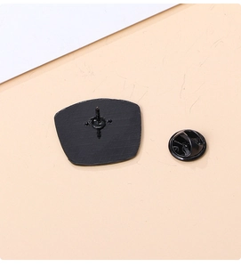 Detailed macro view of a black metal enamel pin back with matching butterfly clutch