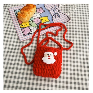 Close-up of red hand-woven kids purse with 3D Santa Claus figure and shoulder strap