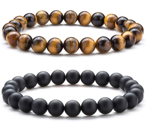 Detail of tiger eye and black obsidian beaded stretch bracelets set on white background