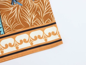 Detail of orange and beige coconut palm print on high-quality polyester maxi dress hem