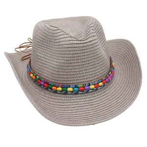 Close-up of woven straw cowboy hat with colorful beaded ethnic band and chin straps