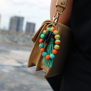 Close-up of silicone beaded keychain bracelet with colorful tassel and metal clasp detail