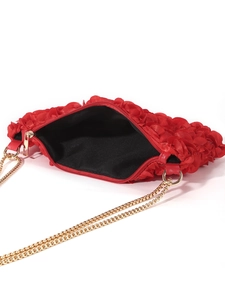 Detail of red floral evening bag with golden chain strap and black lining interior