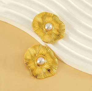 Vue détaillée des boucles d'oreilles pétales en or avec relief et perle centrale