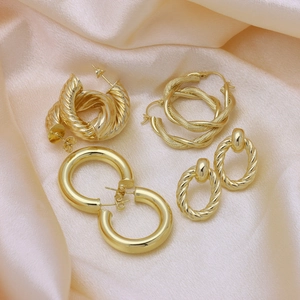 Set of four pairs of 18k gold plated twisted C-shape stud earrings on pink silk