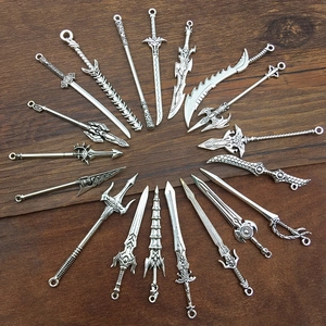 Set of retro silver alloy sword pendants displayed on vintage dark wood background
