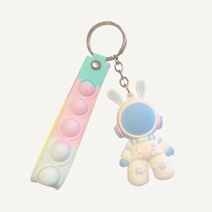 Cute white astronaut keychain with rainbow pop-it stress relief strap on white background