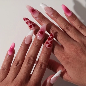 Almond press-on nails with red heart patterns and French tip gradient design