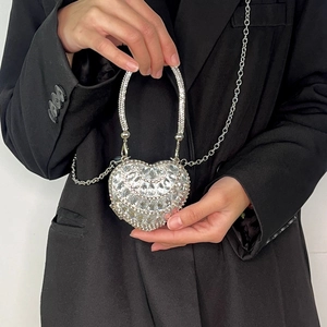 Detail of silver heart-shaped evening bag with crystal rhinestones and diamond handle