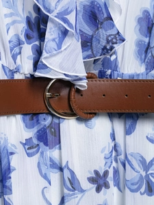 Détail d'une robe en mousseline fleurie avec fine ceinture en cuir marron et boucle métal