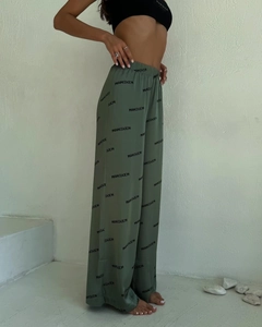Detailansicht der olivgrünen Hose mit hoher Taille, weitem Bein und schwarzem Logo-Print