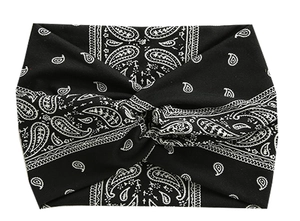 Detail view of black paisley stretch headband with a twist knot for yoga and running