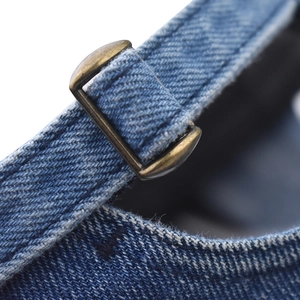 Macro detail of denim baseball cap back strap with vintage bronze metal buckle