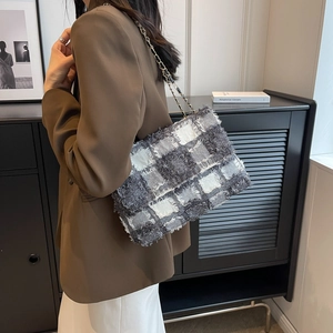 Chic grey plaid tweed shoulder bag with chain strap worn by a model in a blazer