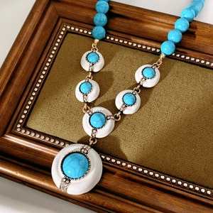 Detailed view of vintage turquoise resin necklace with gold accents and rhinestones