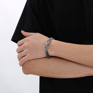 Macro detail of retro snake scale texture and serpent head on stainless steel bracelet