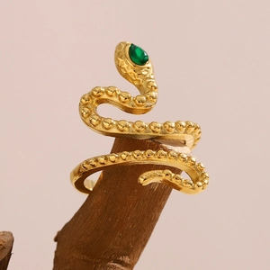 Detailed view of snake ring with green pear-cut gemstone on a wooden display