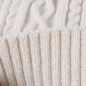 Warm off-white cable knit winter hat with ribbed cuffs and thick thermal wool texture