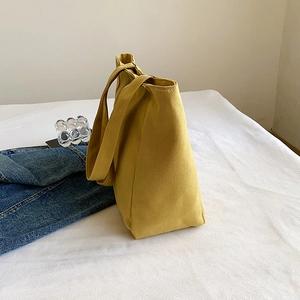 Fashionable ginger yellow canvas tote bag shown from a side view with a minimalist setting
