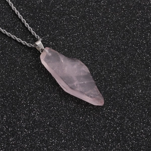 Détail du pendentif en cristal rose irrégulier sur une chaîne torsadée argentée