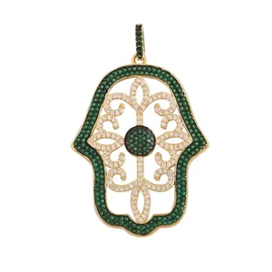 Detail showing a gold Hamsa Hand pendant with micro-pave green and white cubic zirconia