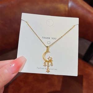 Macro detail of gold crescent moon and star pendant necklace with zircon inlay