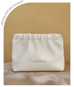 Detail of white PU leather pouch with golden Twinkle little Star print and pleated top