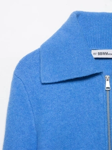 Detailed close-up of the royal blue knit fabric texture and classic zipper collar detail