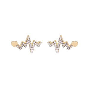 Macro detail of gold heartbeat earrings with paved zircons and a small metal heart