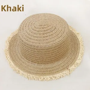 Détail d'un chapeau en paille kaki avec des bords effilochés tendance et un tissage plat