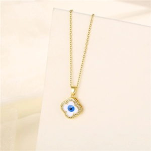 Gold clover necklace with zircon evil eye pendant on a minimalist background