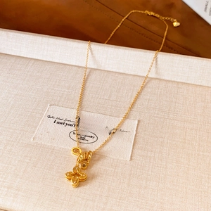 Collier avec pendentif fleur plaqué or et cristaux de zircon sur boîte à bijoux