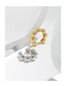 Macro shot of gold and silver S925 sterling silver ear cuffs with spherical texture