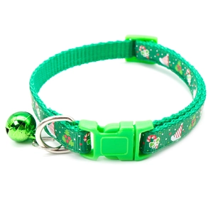 Close-up of green Christmas pet collar with snowflake patterns and small metal bell