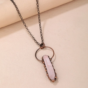 Nahaufnahme eines Vintage-Rosa-Quarz-Anhängers mit antiker bronzefarbener Metallkette