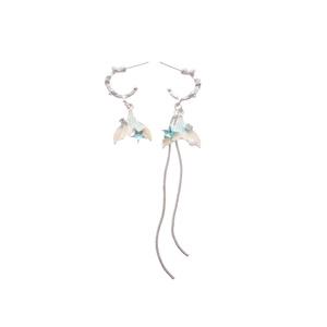 Asymmetric fishtail drop earrings with blue star crystals and elegant pearls on white background