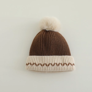 Detailansicht der gerippten Kinder-Strickmütze mit Wellenmuster und Bommel-Textur