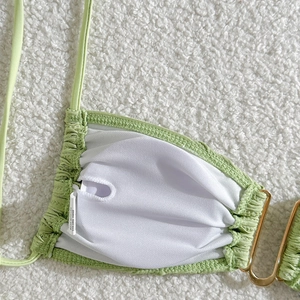 Detail of light green textured bikini top showing inner lining and pad insertion pocket