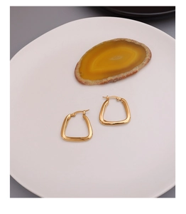 U-shaped geometric earrings in 18K gold plated titanium steel on a white plate