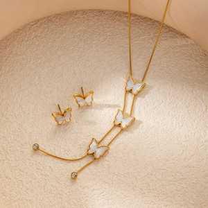 Detailed macro view of butterfly jewelry set with white mother of pearl and gold plating