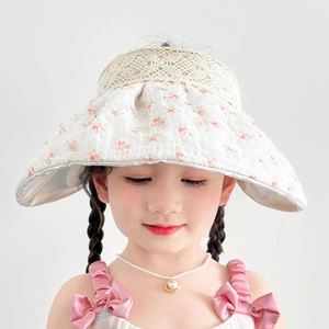 Détail du chapeau soleil enfant avec bord en organza fleuri et dessus en dentelle ajourée