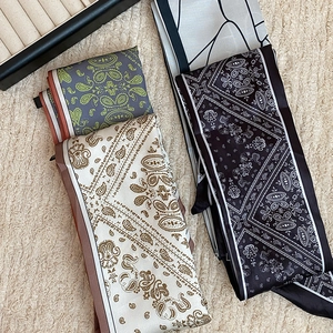 Retro paisley print silk scarves in grey, beige and black on soft textured background