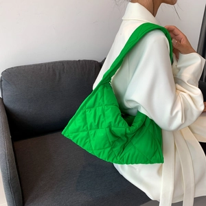 Vibrant green quilted nylon puffer bag shown on model for a trendy oversized casual look