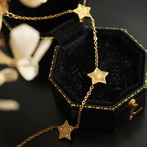 18K gold plated star necklace with zircon inlays on a black velvet hexagon jewelry box