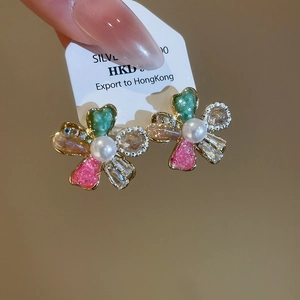 Detailed close-up of a flower crystal stud earring featuring a white pearl center on card