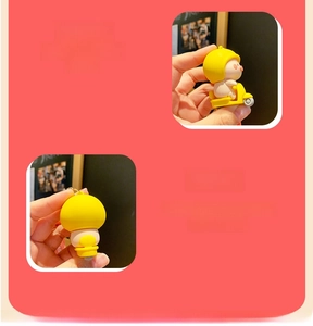 Detail view showing a yellow cartoon pig figurine keychain with a durable silicone texture