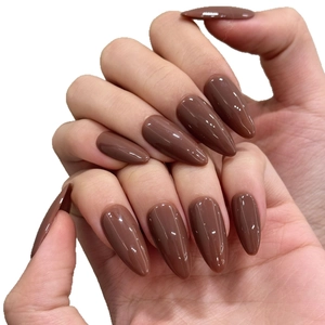 Unghie finte a mandorla color marrone caffè lucido per donne su uno sfondo bianco pulito
