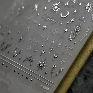 Macro shot of silver laser nail stickers with star and moon patterns, model to 1880