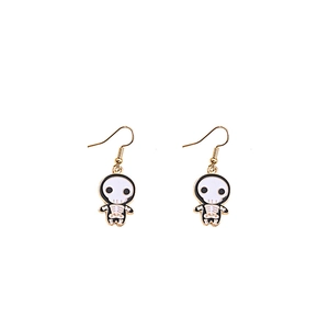 Close-up of cartoon skull drop earrings with black and white enamel and gold trim finish