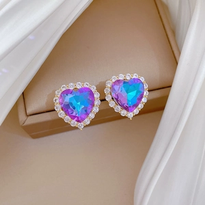 Detail of heart stud earrings with gradient blue-purple stones and sparkling crystals